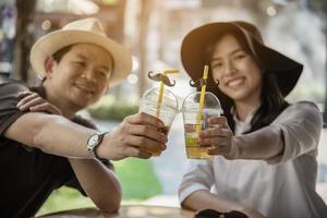 casal asiático gosta de viajar sentado no café - jovens felizes no conceito de férias foto