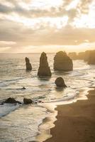 vista de doze apóstolos uma formação rochosa icônica durante o pôr do sol na grande estrada oceânica do estado de vitória da austrália. foto