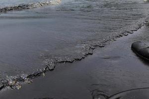 derramamento de petróleo bruto na praia foto