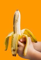 banana na mão isolado em fundo laranja foto