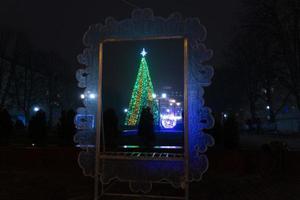 árvore de natal, árvore de ano novo lá fora à noite sob a neve. foto