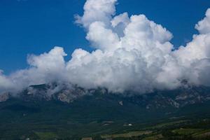 enormes nuvens cumulus brancas sobre um vale de montanha com vinhas na criméia. foto