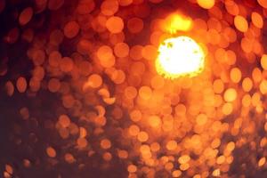 fundo de bokeh de luz noturna laranja. vida urbana. desfocar o fundo abstrato da luz urbana. luz quente com belo padrão de bokeh redondo. luz de natal à noite. lâmpada de rua luzes borradas. foto