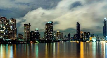 paisagem urbana do edifício moderno perto do rio no meio da noite. prédio de escritórios de arquitetura moderna. arranha-céu com céu noturno. imagem de tom preto e branco. fotografia noturna do edifício ribeirinho. foto