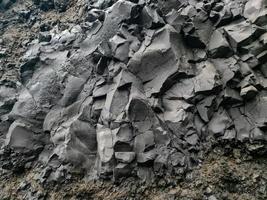 incríveis estruturas rochosas de basalto na interminável praia negra da islândia. foto