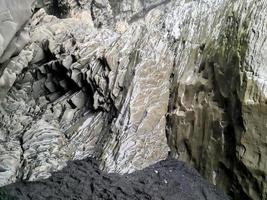 incríveis estruturas rochosas de basalto na interminável praia negra da islândia. foto