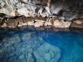 vista na caverna de lava grjotagja com água azul cristalina. foto