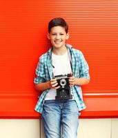 feliz sorridente menino adolescente com câmera retro vintage