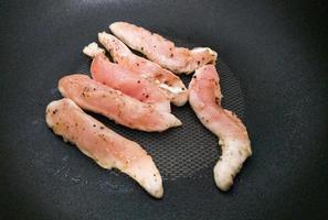 o foco seletivo do filé de frango fatiado temperado com sal e pimenta do reino. foto