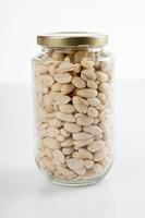 amendoins descascados em uma jarra com tampa fechada foto