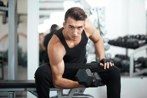 homem fazendo exercícios halteres músculos bíceps foto