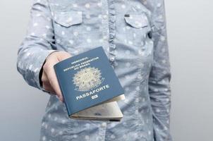 mulher caucasiana, segurando um passaporte brasileiro