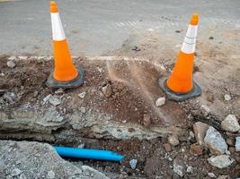 o novo tubo de pvc está colocado na vala perto da estrada de asfalto para o sistema de abastecimento de água. foto