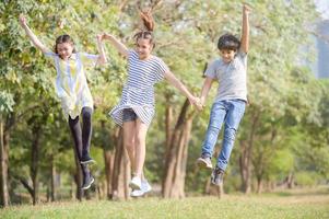 um menino meio tailandês e uma namorada meio tailandesa-europeia correm em um parque enquanto aprendem fora da escola foto