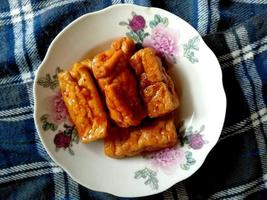 tempe goreng ou tempeh frito em um prato. comida culinária indonésia foto