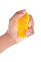 mão afro-americana, apertando uma fatia de laranja foto