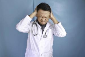 um retrato de um jovem médico asiático parece cansado e sobrecarregado foto