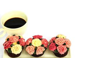 xícara de café e cupcake de rosas sobre fundo branco foto