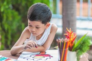 menino está pintando imagens coloridas em casa. foto está focada em seus olhos.