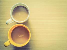 par de xícara de café sobre a mesa de madeira de prancha marrom foto