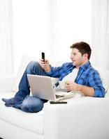 homem relaxado com computador escrevendo texto no celular