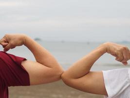 duas mulheres apertos de mão alternativos saudação de cotovelo na situação de uma epidemia covid 19, coronavírus novo distanciamento social normal foto