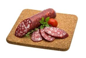 salsichas de salame na placa de madeira foto