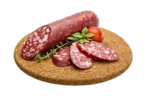 salsichas de salame na placa de madeira foto