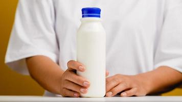 mãos e garrafas. prepare-se para beber leite, beber leite saudável, leite fresco do batedor de leite. foto