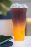 café misturado com suco de laranja em vidro plástico