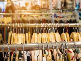 roupas penduradas na prateleira na loja de roupas foto