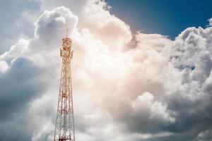 torre de telecomunicações do telefone móvel com nuvem branca e fundo de montanha de céu azul foto