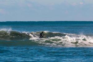 surfista preto roupa de mergulho surfando a onda