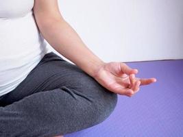 mulher grávida fazendo yoga em casa foto