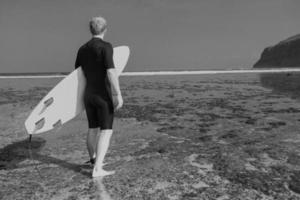 surfista com prancha de surf no litoral foto