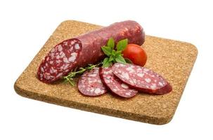 salsichas de salame na placa de madeira foto