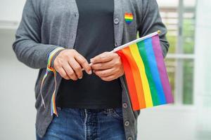 mulher asiática com bandeira do arco-íris, direitos do símbolo lgbt e igualdade de gênero, mês do orgulho lgbt em junho. foto