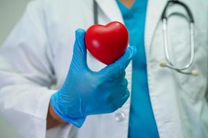 médico de mulher asiática segurando coração vermelho para saúde no hospital.