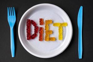 placa de plástico branca com dieta de texto de geleia doce. ursinhos de goma de frutas doces. alimentação saudável, junk food, dieta e conceito de emagrecimento, vista superior. foto