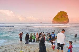 malang, indonésia, 2022 - atmosfera de praia com pessoas conhecendo fotos durante o feriado de eid al-fitr após a pandemia de 2022 na costa de goa china, malang