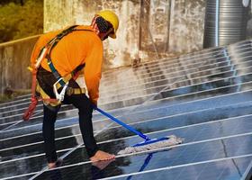 técnicos fotovoltaicos estavam limpando e lavando a superfície dos painéis solares que tinham poeira e cocô de pássaros foto