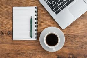 xícara de laptop, notebook e café na mesa de trabalho foto