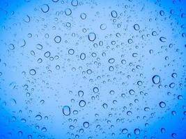 gotas de chuva em um vidro azul, fundo azul abstrato. foto