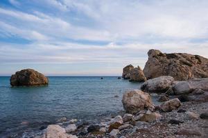 vista da tarde das rochas e da praia ao redor do local de nascimento de petra tou romiou afrodite em paphos, chipre foto