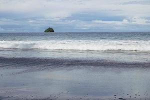 uma pequena ilha no oceano com ondas do mar foto