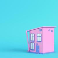 casa estilo cartoon rosa sobre fundo azul brilhante em tons pastel foto