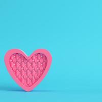 forma de coração abstrato rosa sobre fundo azul brilhante em tons pastel foto