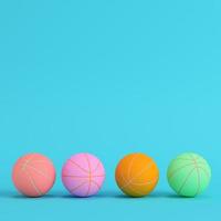 quatro bolas de basquete em fundo azul brilhante em tons pastel. conceito de minimalismo foto