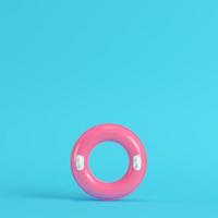 anel inflável rosa em fundo azul brilhante em tons pastel foto