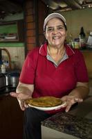 chef de mulher nos mostra uma omelete feita na hora. foto